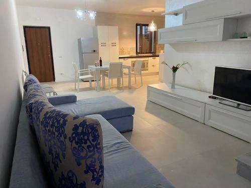ein Wohnzimmer mit einem Sofa und einem TV in der Unterkunft Nunzia’s house! in Castel Volturno