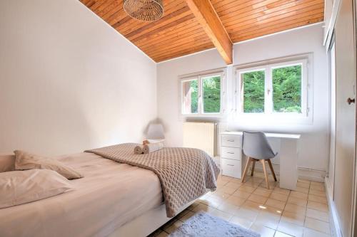 um quarto com uma cama, uma secretária e janelas em Secret Garden em Périgueux