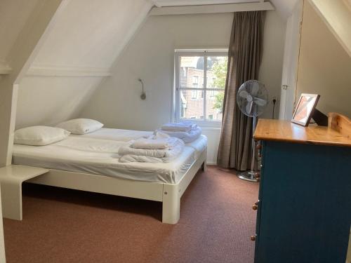 a bedroom with a bed with towels on it at Family fisherman's house Volendam in Volendam