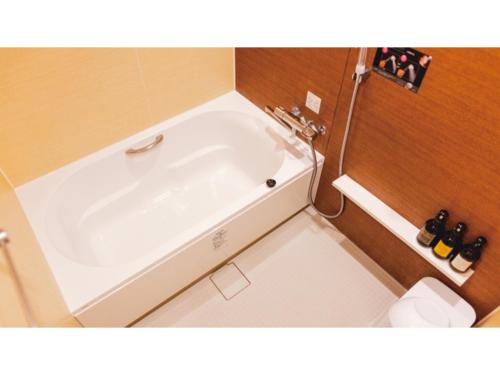 a white bath tub in a small bathroom at AIRAIKU HOTEL Kagoshima - Vacation STAY 17445v in Aira