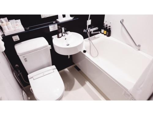 a bathroom with a toilet and a sink and a tub at AIRAIKU HOTEL Kagoshima - Vacation STAY 17451v in Aira