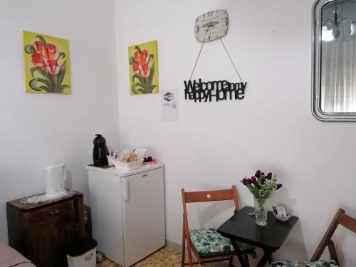 um quarto com um pequeno frigorífico e uma mesa com uma cadeira em Melissa lux em Ciampino
