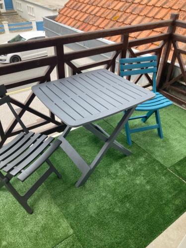 a picnic table and two chairs on a patio at La Baie L’Etoile, Apt 4 pers, bord de mer, parking privé, Fort Mahon Plage in Fort-Mahon-Plage