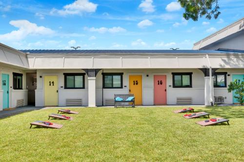 a building with colorful doors on the grass at Hotel McCoy - Art, Libations, Pool Society in College Station