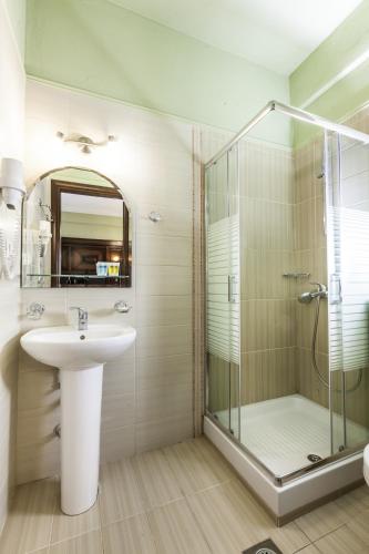 a bathroom with a glass shower and a sink at Dellas Boutique Hotel in Kalabaka