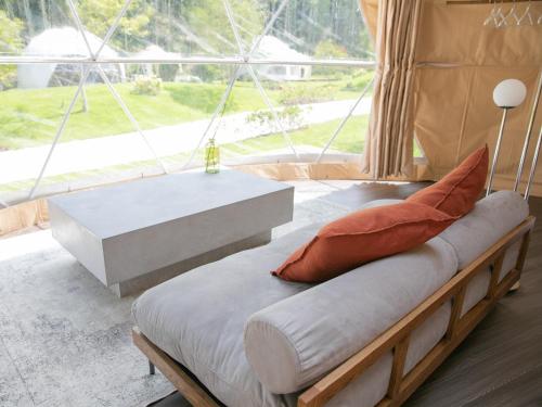 野間にあるBAMBOO RESORT MIHAMA TSUNAGI - Vacation STAY 43081vのベンチ、テーブル、窓が備わる客室です。