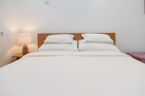 a white bed with white sheets and pillows at Apartment Slavia District in Belgrade