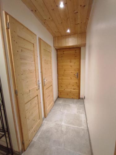 a hallway with two wooden doors and a tile floor at Grand Studio Val Cenis in Lanslebourg-Mont-Cenis