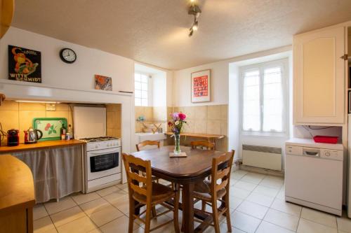 uma cozinha com uma mesa de madeira e uma sala de jantar em Gîte de Champdoré em Nanthiat