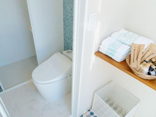 a bathroom with a toilet and a basket of towels at BAMBOO RESORT MIHAMA TSUNAGI - Vacation STAY 43074v in Noma