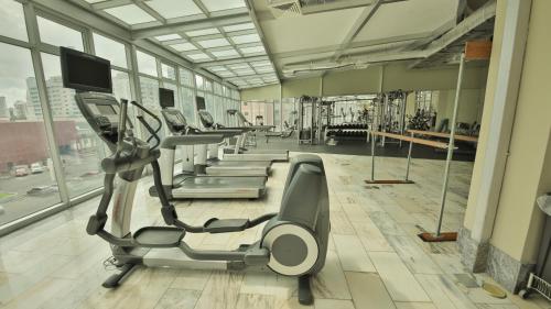 a gym with a row of treadmills and machines at Torres de Alba Hotel & Suites in Panama City