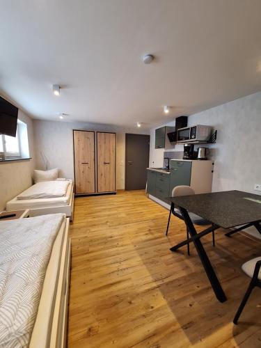Zimmer mit einem Bett und einem Tisch sowie einer Küche in der Unterkunft Pension Eichsfeld Zimmer 4 Standard in Breitenworbis