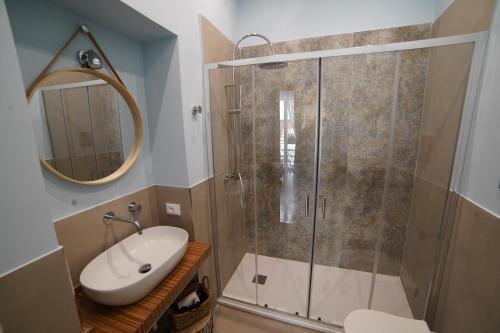 Un baño con ducha, lavabo y espejo. en Domus Maqueda, en Palermo