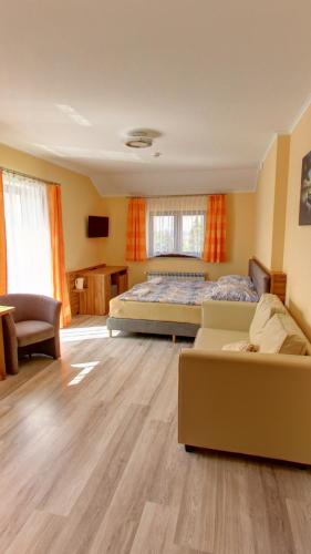 a bedroom with a bed and a couch at Apartamenty i pokoje z basenem AVENA Jastrzębia Góra in Jastrzębia Góra