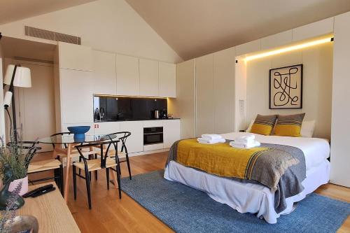 a bedroom with a bed and a table and a kitchen at Fontainhas Hidden Gem in Porto
