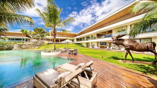 a house with a statue of a rhino next to a pool at Sunny Vacation Villa no 1 in Bonao