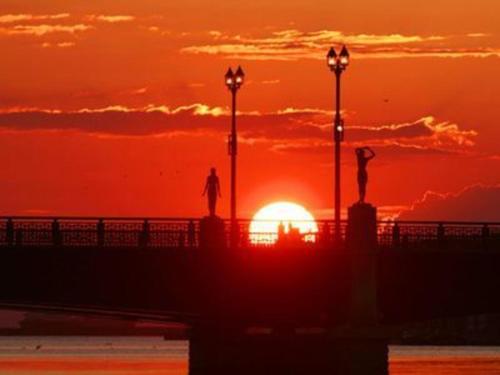 a sunset on the beach with two people standing on a pier at Hotel Axia Inn Kushiro - Vacation STAY 67246v in Irifunechō