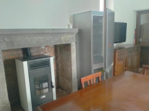 Canino的住宿－Appartamento Indipendente，厨房配有壁炉、桌子和电视