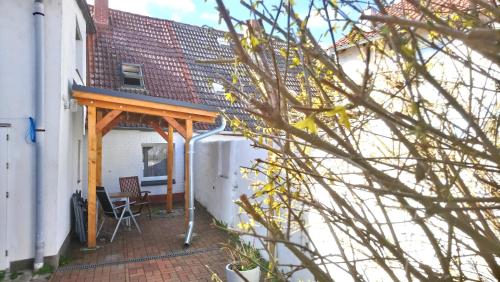 a patio with a wooden pergola next to a building at Neukalener Stadthaus Zum Alten Schmied in Neukalen