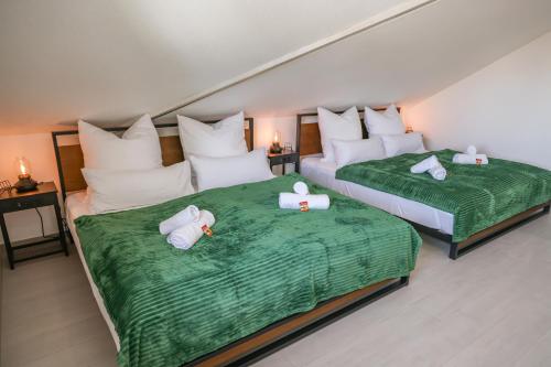 two beds in a hotel room with towels on them at Penthouse-Wohnung I 100 qm I Blick auf die Weinreben I Nespresso I EMMA Matratzen in Auggen