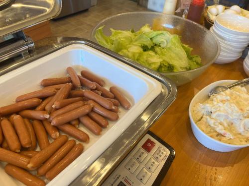 a tray of hot dogs and salad next to a scale at Hotel Axia Inn Kushiro - Vacation STAY 67235v in Irifunechō