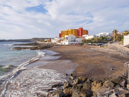 a view of the beach with buildings in the background at Live el Poris chinchorro in Poris de Abona
