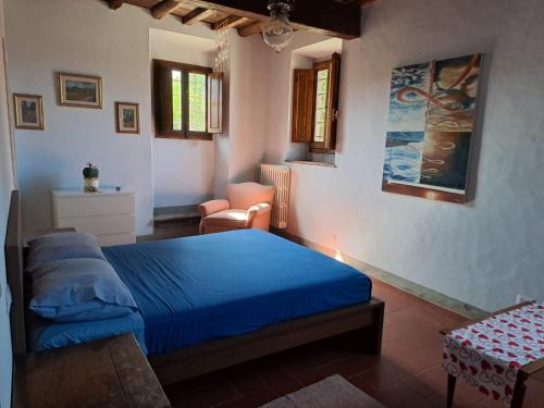 a bedroom with a blue bed and a chair at Sunshine Suites in Florence