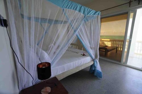 una camera da letto con letto e zanzariera bianca di Kome apartment two a Jambiani