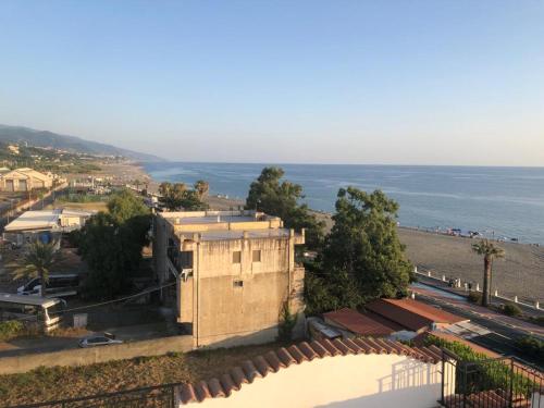 a view of a building with the ocean in the background at La terrazza di Brancaccio’s house summer in Paola