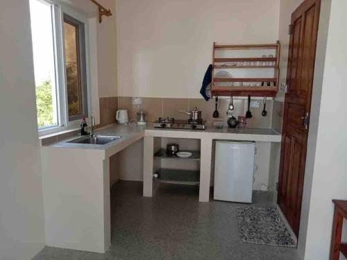 una piccola cucina con lavello e frigorifero di Kome apartment two a Jambiani