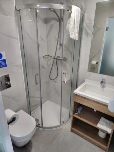 a bathroom with a shower and a toilet and a sink at Homefield Lodge in London