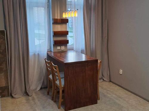 una scrivania con sedia in una stanza con finestra di Kael Apartment a Teplice