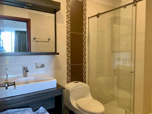 a bathroom with a toilet and a sink and a shower at Serenity Suites Casa Boutique in Bucaramanga