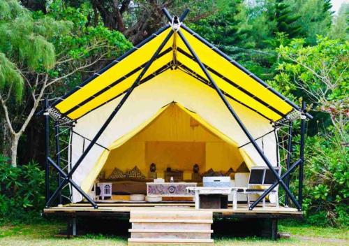 une grande tente jaune avec une table. dans l'établissement Keisaji CAMP SITE - Vacation STAY 90073v, à Ijinabaru