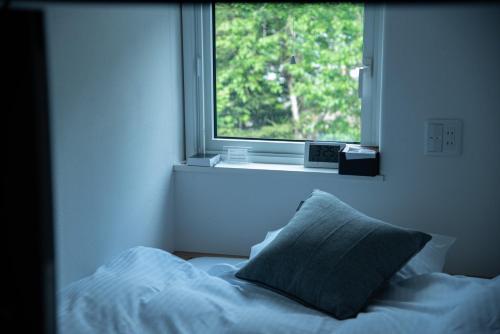 1 cama con almohada frente a una ventana en HOTEL BOTH - Vacation STAY 90911v, en Shari