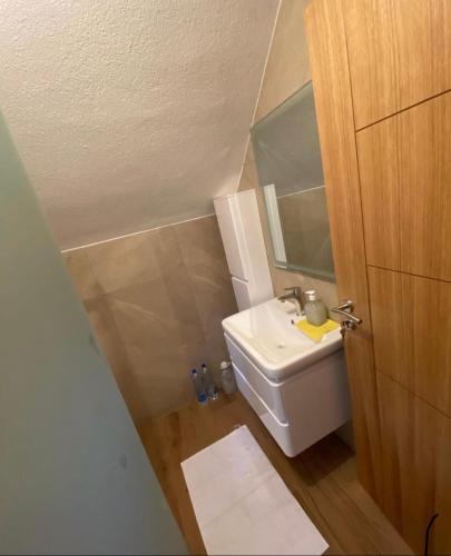 a small bathroom with a sink and a toilet at Villat Twin’s in Peje