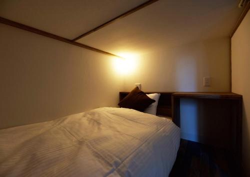 HOTEL BOTH - Vacation STAY 92324v في شاري: غرفة نوم بسرير ابيض وعليها انارة