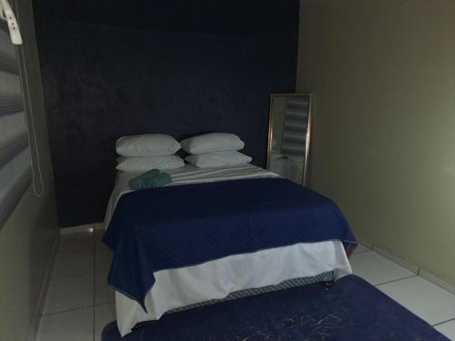 Pretoria的住宿－Queen Light，一张带蓝色和白色床单及枕头的小床