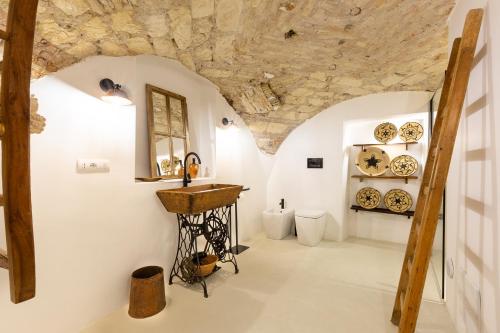 una stanza con lavandino e piatti appesi al muro di Crobi Museum and Suites a Cagliari