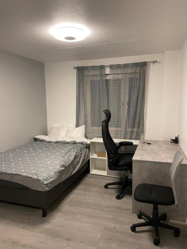 a bedroom with a bed and a desk and a chair at Central Apartment with 3 bedrooms in Norrköping