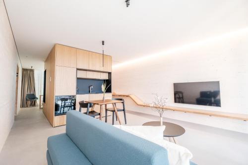 a living room and dining room with a blue couch at Stock & Stein Lodges in Bad Gleichenberg