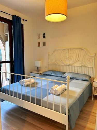 ein Schlafzimmer mit einem weißen Bett mit einer blauen Decke in der Unterkunft Casa Tea in Lucca