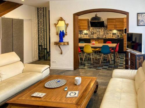 un soggiorno con divano e tavolo di Magnifique maison classée 3 étoiles, 7 chambres, 5 salles de bain, parking privé, Tarbes ville a Tarbes