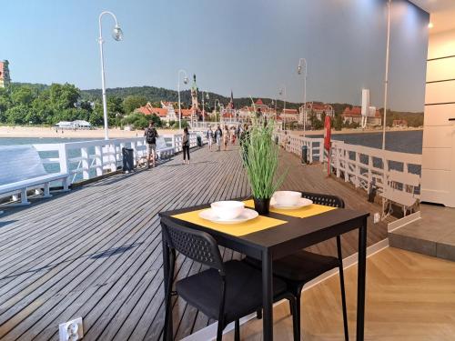 un tavolo nero e sedie su una passerella di 3miasto Gdynia Apartamenty a Gdynia