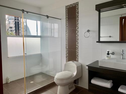 een badkamer met een toilet, een douche en een wastafel bij Serenity Suites Casa Boutique in Bucaramanga