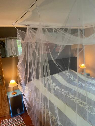 1 cama con dosel y mosquitera blanca en una habitación en Quinta Inge, 