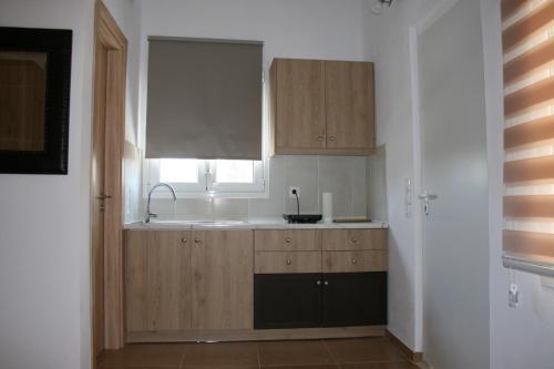 a kitchen with wooden cabinets and a sink and a window at KOLLITAKI in Selínia