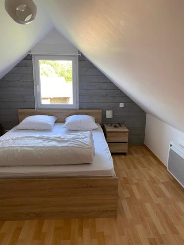 a bedroom with a bed and a window at Le chalet de Thil 