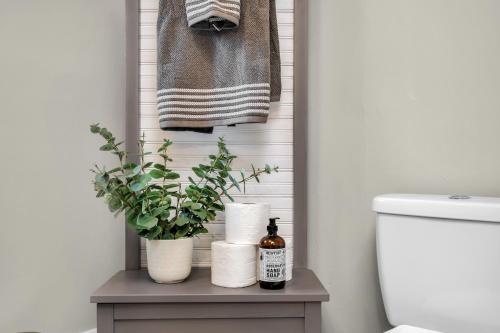 a bathroom with towels and a table with a toilet at Enchanting Bungalow - 2BR Historic Hidden Gem in Xenia