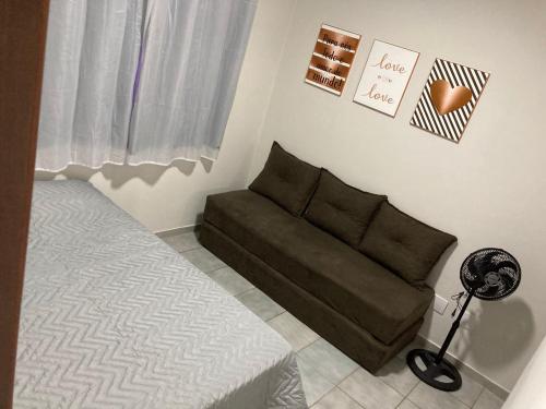sala de estar con sofá y cama en Lindo apartamento na Praia do Morro, en Guarapari